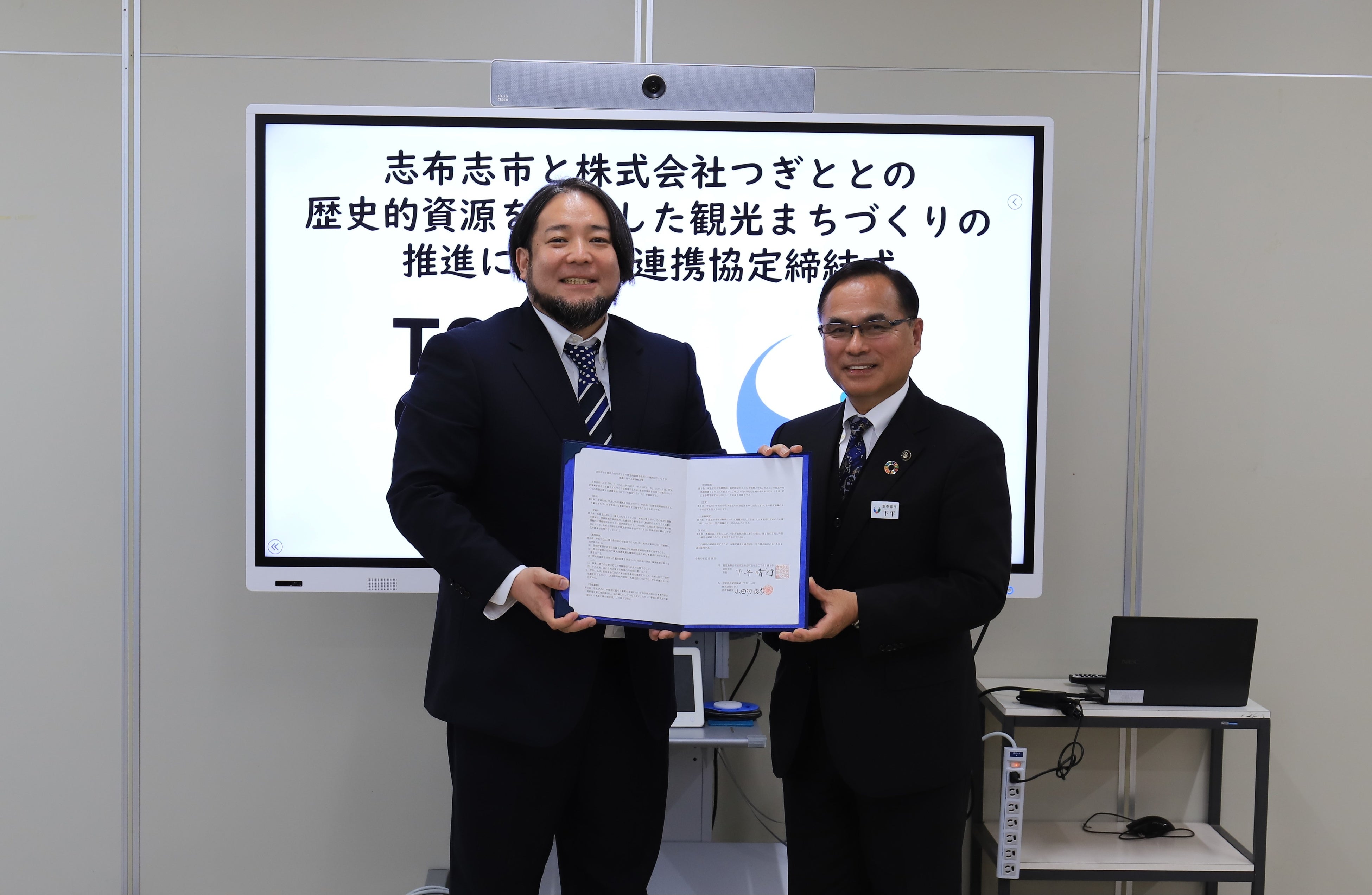 連携協定締結式で協定書を交わす下平晴行市長（右）と株式会社つぎと代表取締役の小田切俊彦