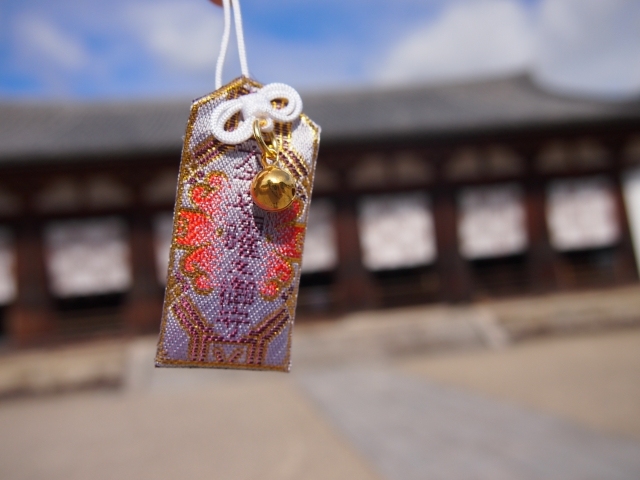神社を背景にした色鮮やかなお守り